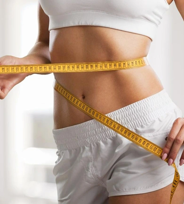 Weight loss compounding: person measuring their waist with a tape measure