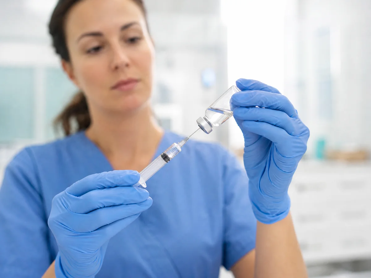 Nurse drawing medication from a vial into a syringe