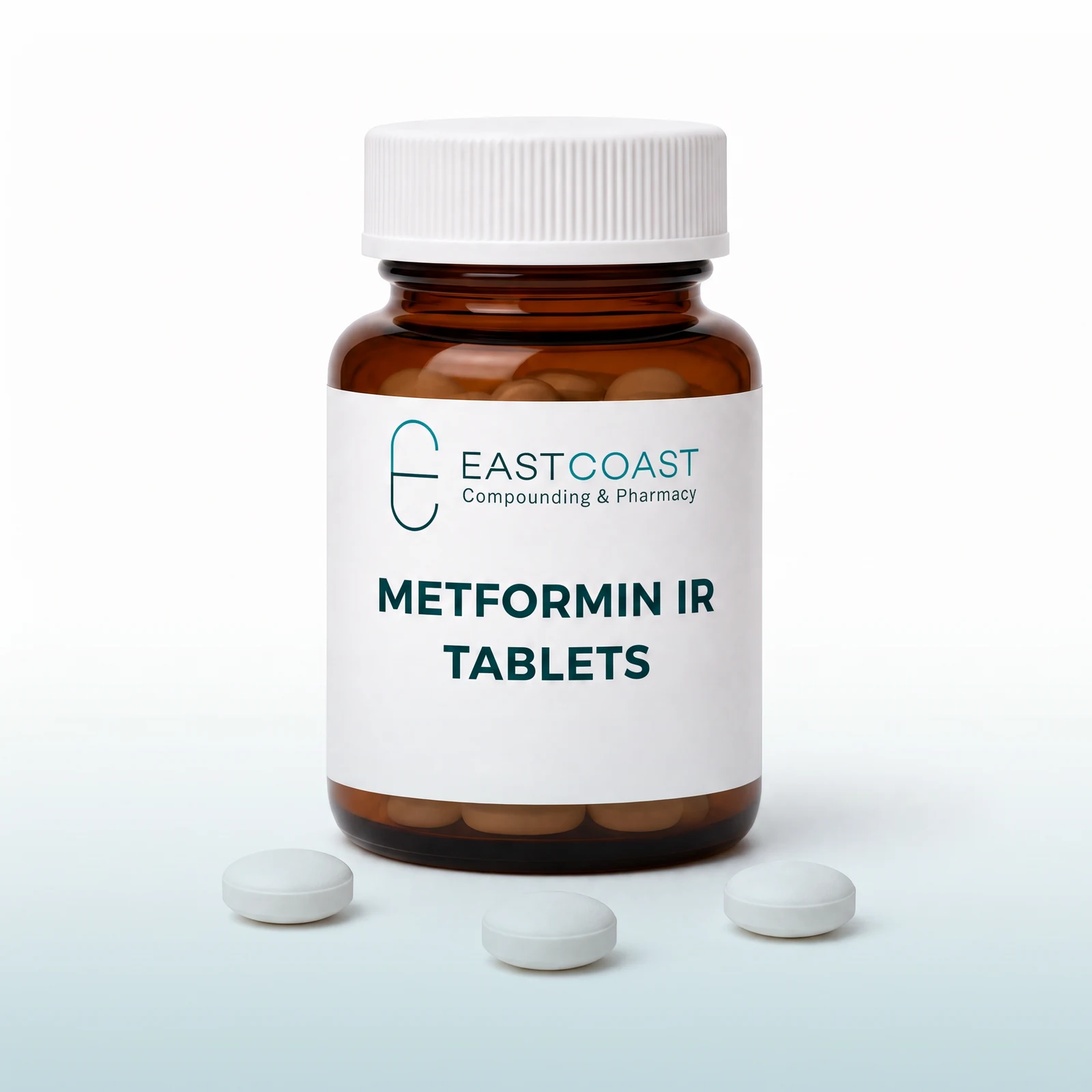 Metformin IR tablets in an amber pharmacy vial with East Coast Compounding & Pharmacy label, white tablets beside it (illustrative image)