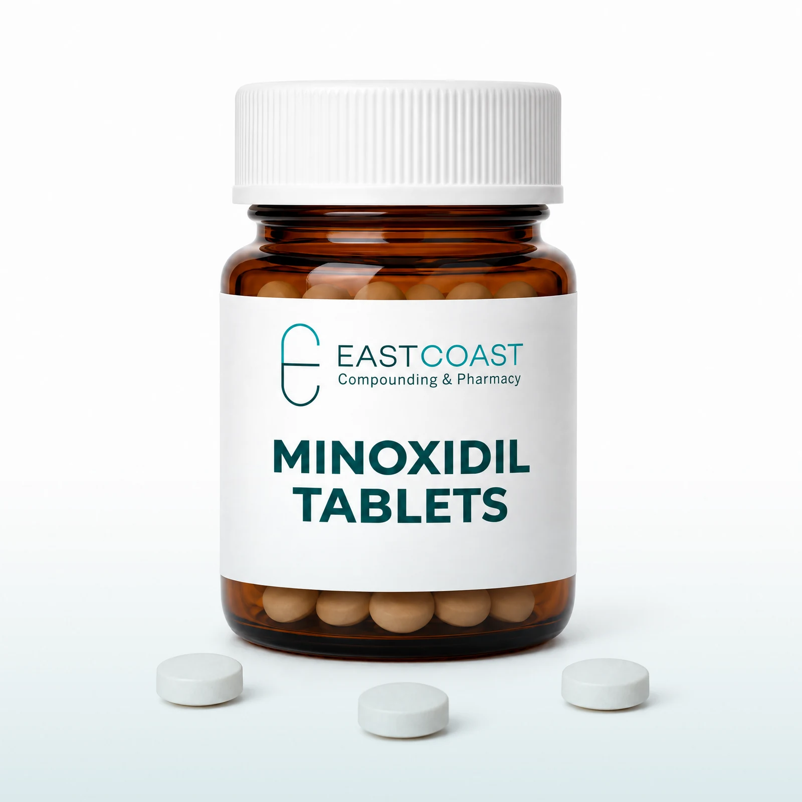 Minoxidil oral tablets in an amber pharmacy vial with East Coast Compounding & Pharmacy label (illustrative image)